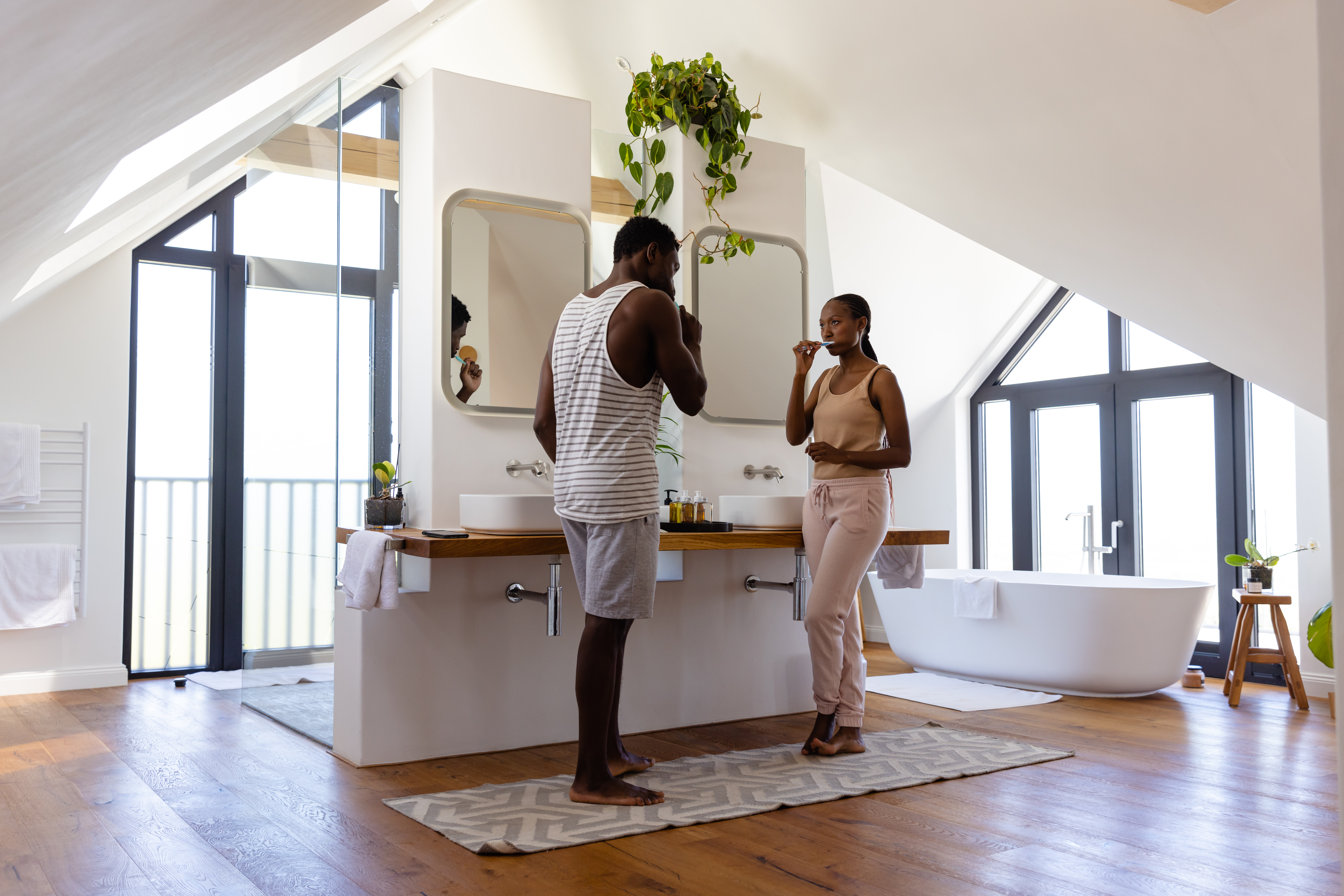 African american couple brushing teeth in bathroom. Lifestyle, relationship, togetherness, hygiene and domestic life, unaltered.
