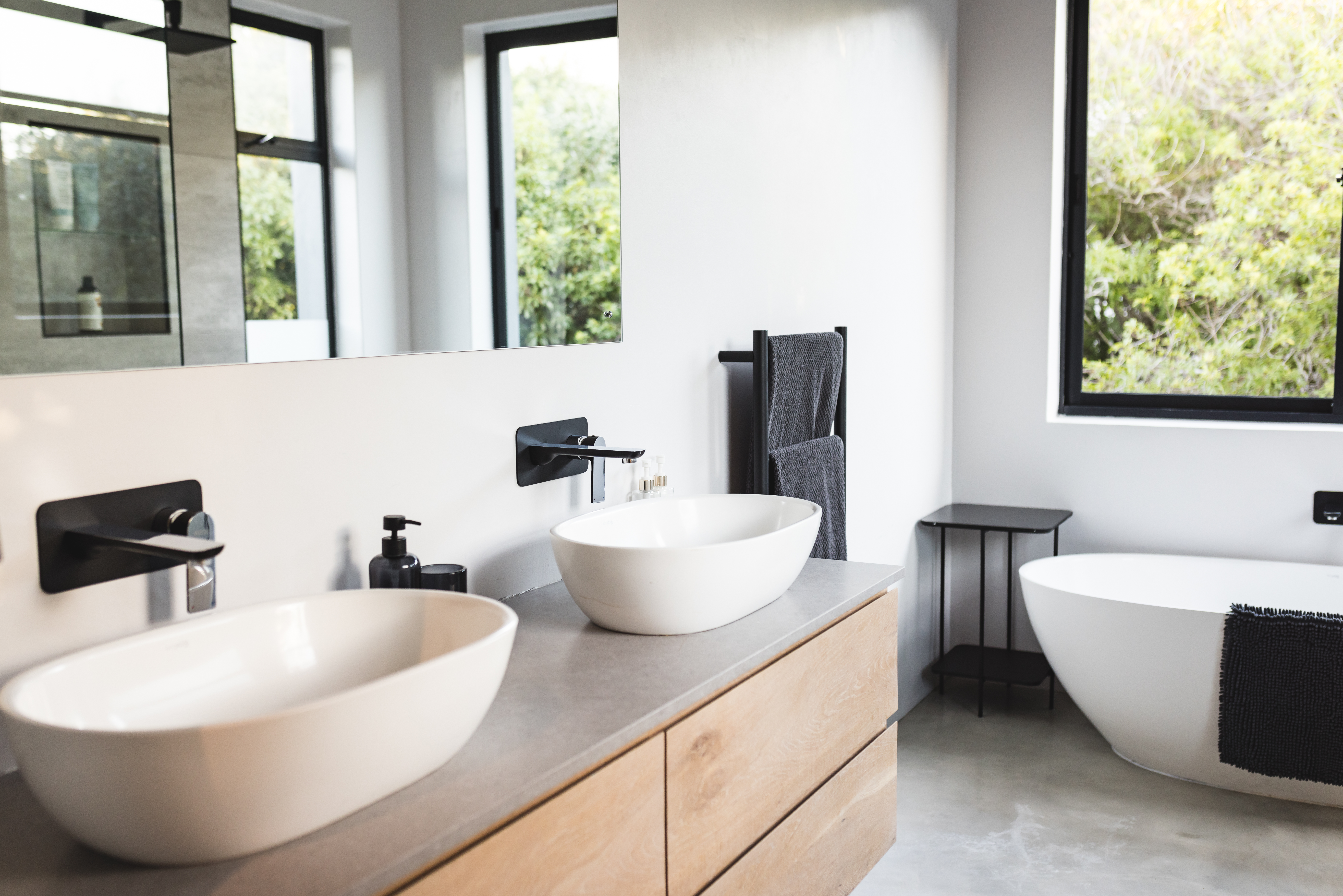 Modern bathroom with double sinks, wooden cabinets, and freestanding bathtub, copy space. interior design, home, luxury, contemporary, minimalist, clean