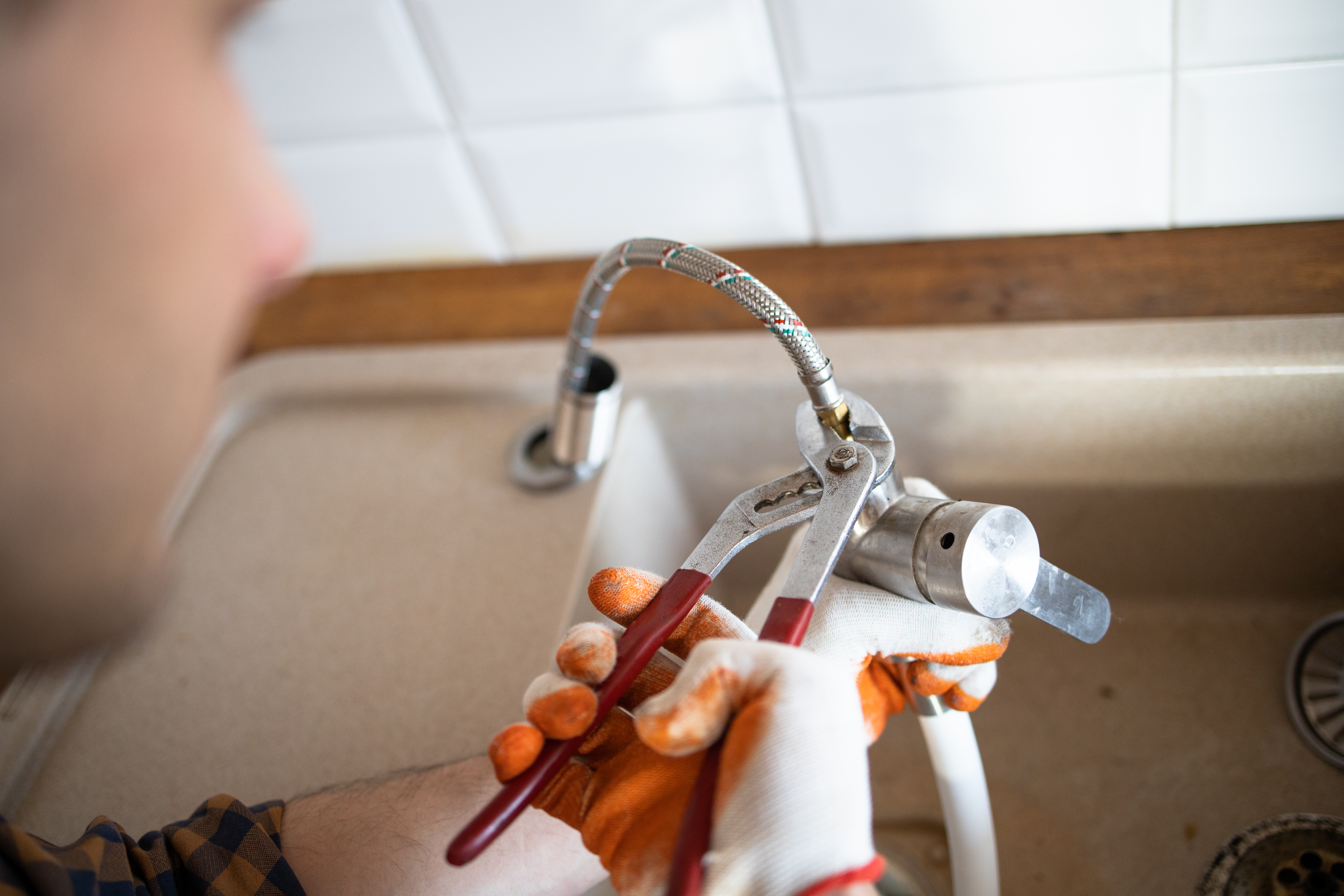 plumber-fixing-faucet-in-a-home-kitchen-sink-2026-03-24-11-39-11-utc